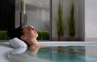 A woman relaxes in a jacuzzi with sunglasses, embodying self-care and relaxation.